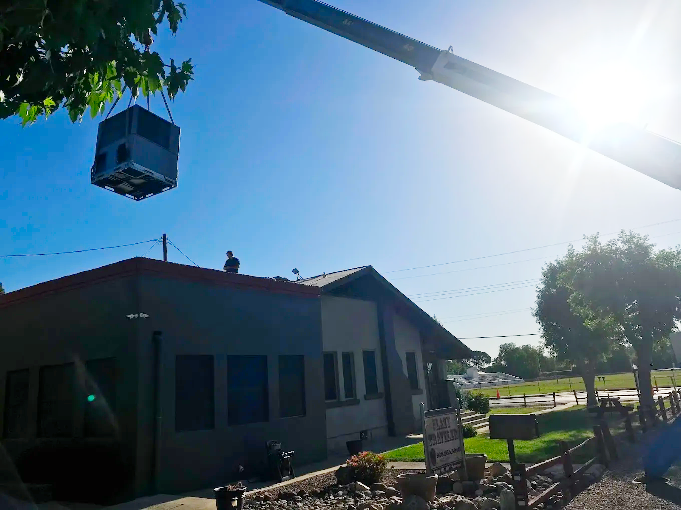 Crane lifting commercial HVAC unit